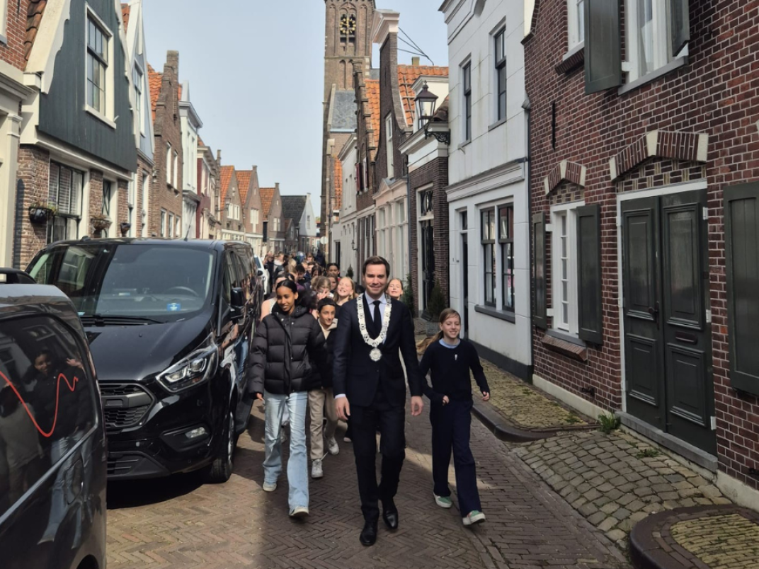 Burgemeester Rick Beukers loopt samen met de leerlingen naar het monument
